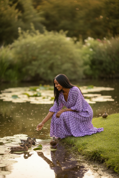 Beautiful Brown Skin Woman Feeding Ducks by the Pond in Purple Bohemian Dress